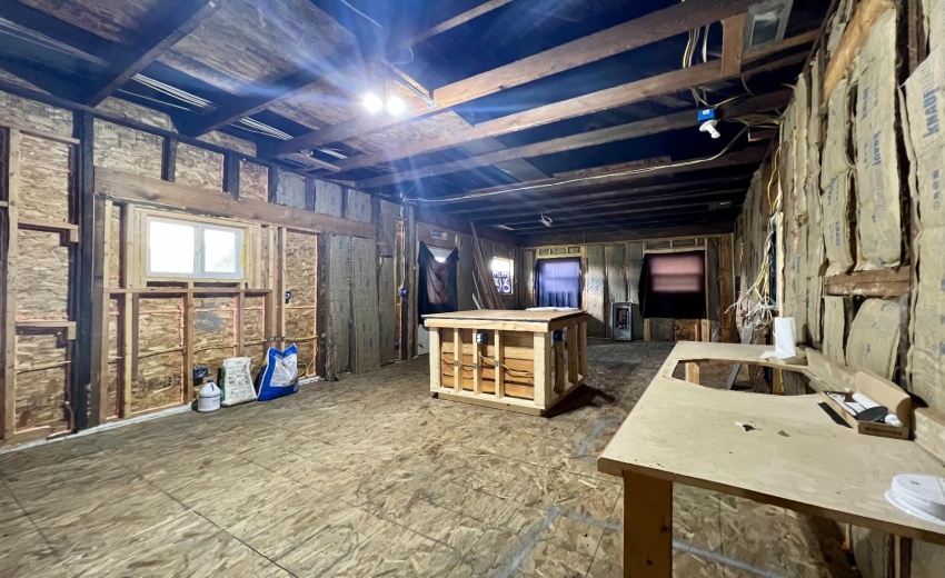Walking into the large open concept kitchen and dining room area with island built over crawl space entry.