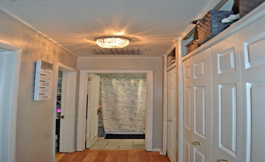 hallway to bathroom with closets